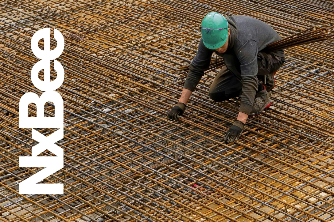 Eisenleger bei der Montage von Bewehrungsmatten auf einer Baustelle – präzise Handarbeit für kostengünstige Betonkonstruktionen